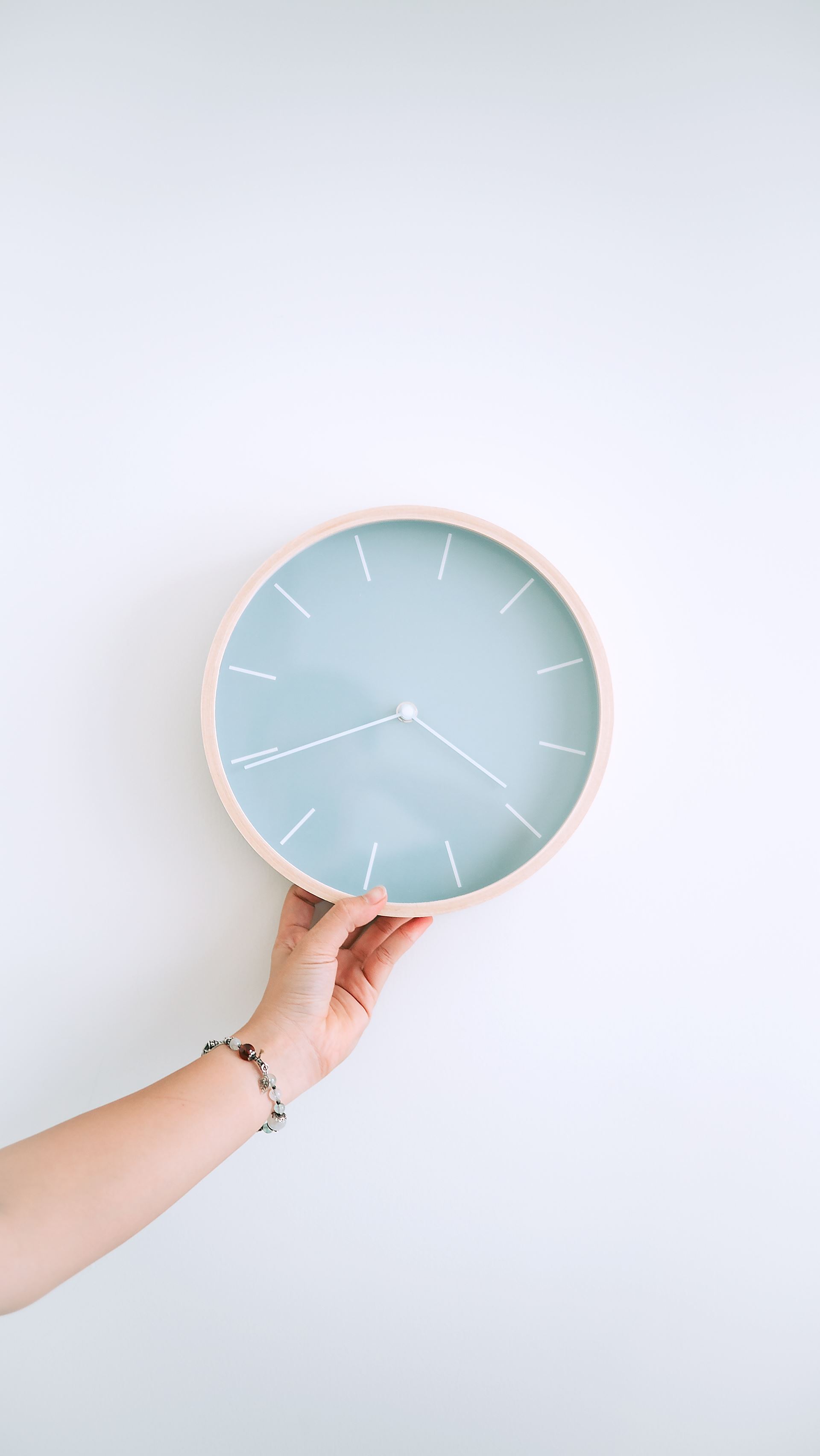 a hand holding a clock